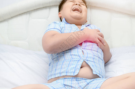 肥胖的子正在从急疼痛和心脏病发作症状中抓取胸腔图片
