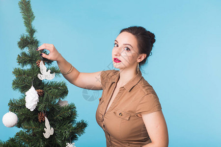 圣诞节和日的概念微笑的女孩与圣诞树在蓝图片