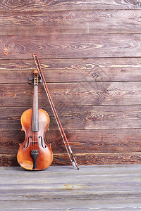 木制背景上的复古小提琴老小提琴弓和复制空间艺图片