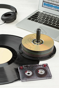 旧的和现代的设备背景黑胶唱片录音带光盘笔记本电脑和耳机音乐图片
