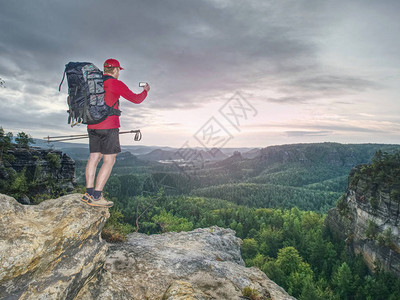 摄影师在大自然中阳光明媚的日子拍摄令人惊叹的风景旅行者摄影师在高山捕图片