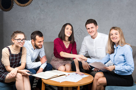 一群年轻的白种人五坐在办公室参加圆桌会议图片