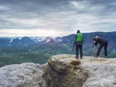 有才华的业余摄影师在岩石上拍照露营探险旅行和旅行图片