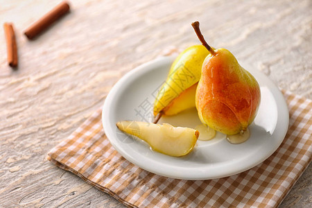 桌上有熟梨和蜂蜜的盘子图片