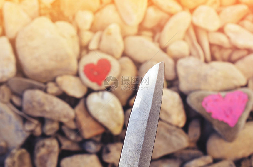 切割刀潜水粉红色的心在一块石头上涂口红爱的结束和两个人分手图片