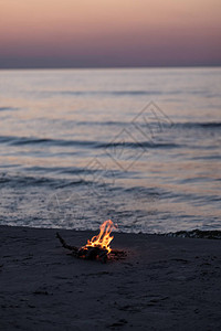 深夜在海边燃烧着小火背景有波浪图片