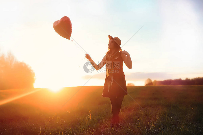 一个戴着帽子的女孩在公园散步一个提着篮子的女孩在秋天散步夕阳西下图片