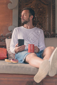 一个人拿着手机咖啡杯沙图片