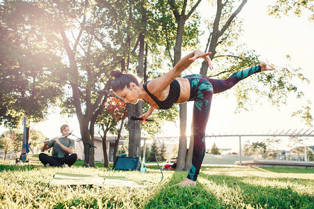 白种人中年妇女在日落时在公园外做瑜伽图片