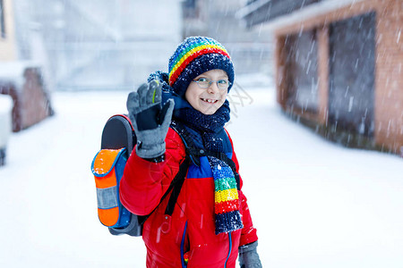 小学生在降雪期间步行去学校的小学男孩图片