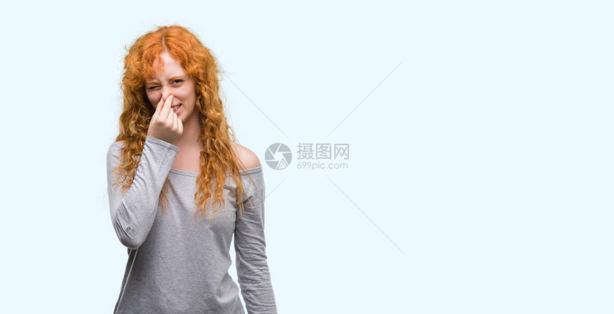 年轻的红发女人闻到某种臭味和恶心难以忍受的气味图片