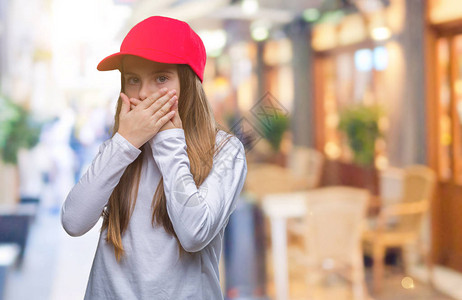 穿着红帽的年轻美女被孤立的背景震惊用双手遮住嘴图片