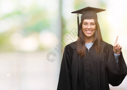 身着毕业帽子和制服的年轻的西班牙女青年露出一指头图片