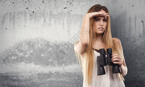 年轻美女用双筒望远镜图片