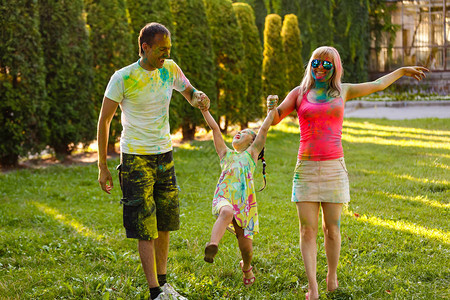 快乐的年轻家庭女儿在绿色公园玩耍图片