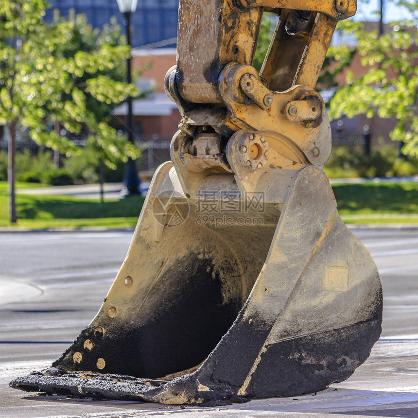 重型挖掘机卡车在路上的桶在阳光明媚的道路上近距离拍摄挖掘机卡车的铲斗结痂的土壤和沙子覆盖了卡车的图片