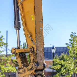 施工车辆肮脏的黄色手臂挖掘机黄色臂的特写视图连接臂和铲斗的铰链上覆盖图片