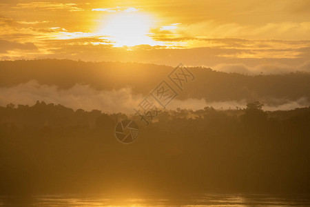 在湄公河的风景日出和雾中清晨美丽的金色时钟在泰国图片