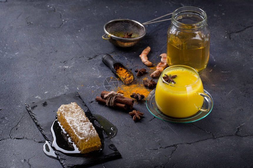 姜黄奶茶配肉桂茴香和姜黄根蜂蜜和粉图片