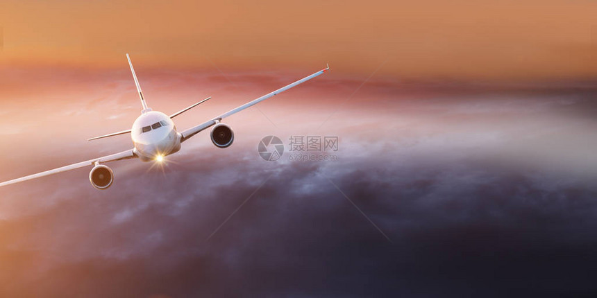 商业飞机在日落时飞越图片