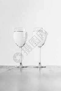木桌上两个装满透明液体的酒杯图片