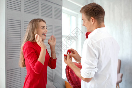 年轻男人向心爱的人求婚在家里用漂亮的图片