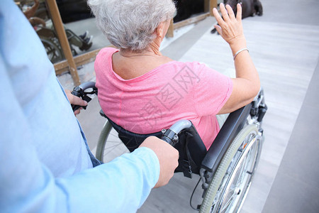 坐在轮椅上的老年妇女和在户外图片