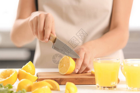 在餐桌上切新鲜柠檬汁的女人图片
