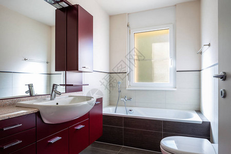 浴室有红色衣橱浴缸和窗图片