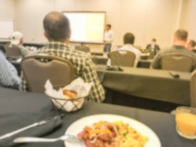 在旅馆宴会室举行的讲习班或商务会议桌上边吃着大陆餐桌的图片
