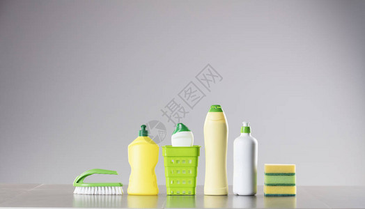 房子和办公室清理主题一套不同的彩色清洁产品在瓶子和海绵和灰色图片