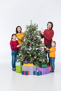 家庭幸福快乐的圣诞树装饰着玻璃球图片