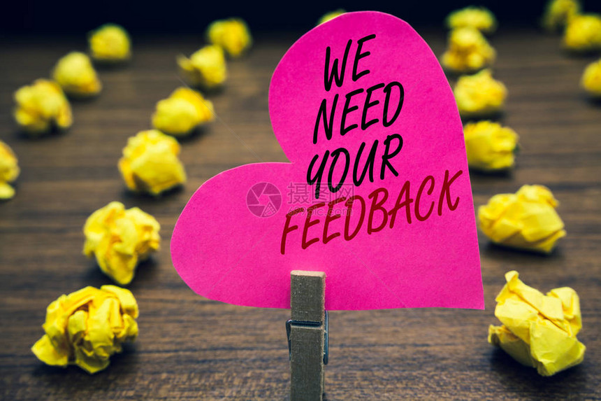 概念手写显示我们需要您的反馈商业照片文本给我们您的评论想法评论有什么需要改进的回形针持有粉红色的写心木地板和黄图片
