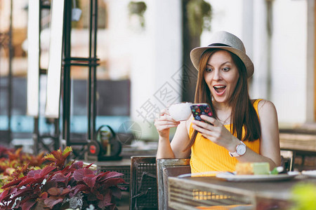 女人在户外街头咖啡店咖啡馆坐在桌边图片