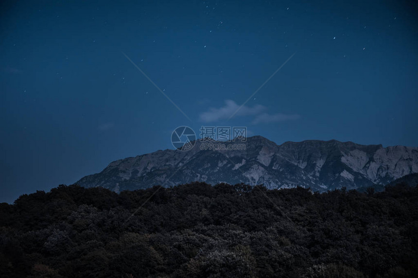 美丽的夜景与星夜山和森林有绿色草甸和山的夜森林在明亮的星夜图片