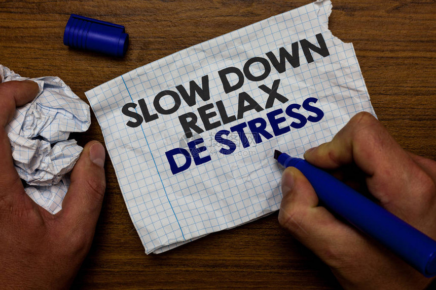 休息的商业概念降低压力水平休息冷静手握纸吊和蓝色标记木底座图片