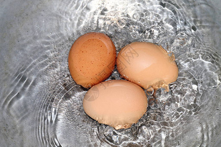 鸡蛋锅里煮的鸡蛋热水里的Raw蛋红黄正在煮饭图片