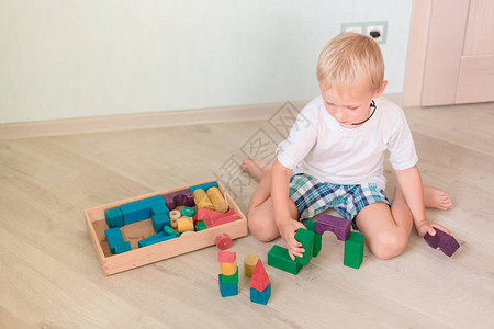 在房间里玩有色木块的可爱小男孩早期发展概图片