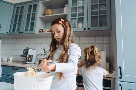 两个小女孩一起在厨房做饭图片