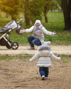 小女孩在公园里推着婴儿车跑到妈身边妈和女儿图片