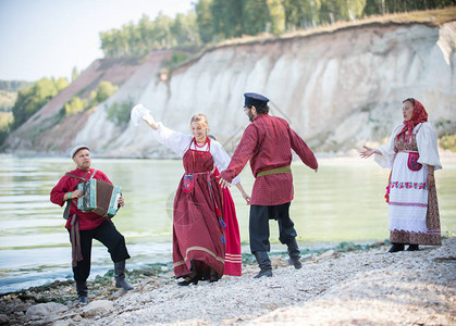 穿红色俄罗斯民族服装的年轻人在民间舞蹈中跳舞图片