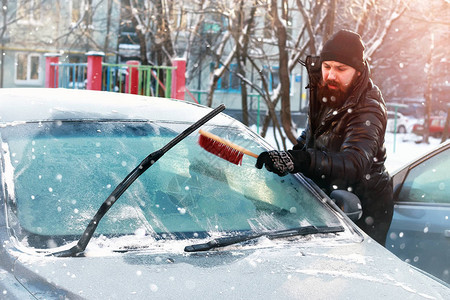 男人在车上擦玻璃上的雪图片