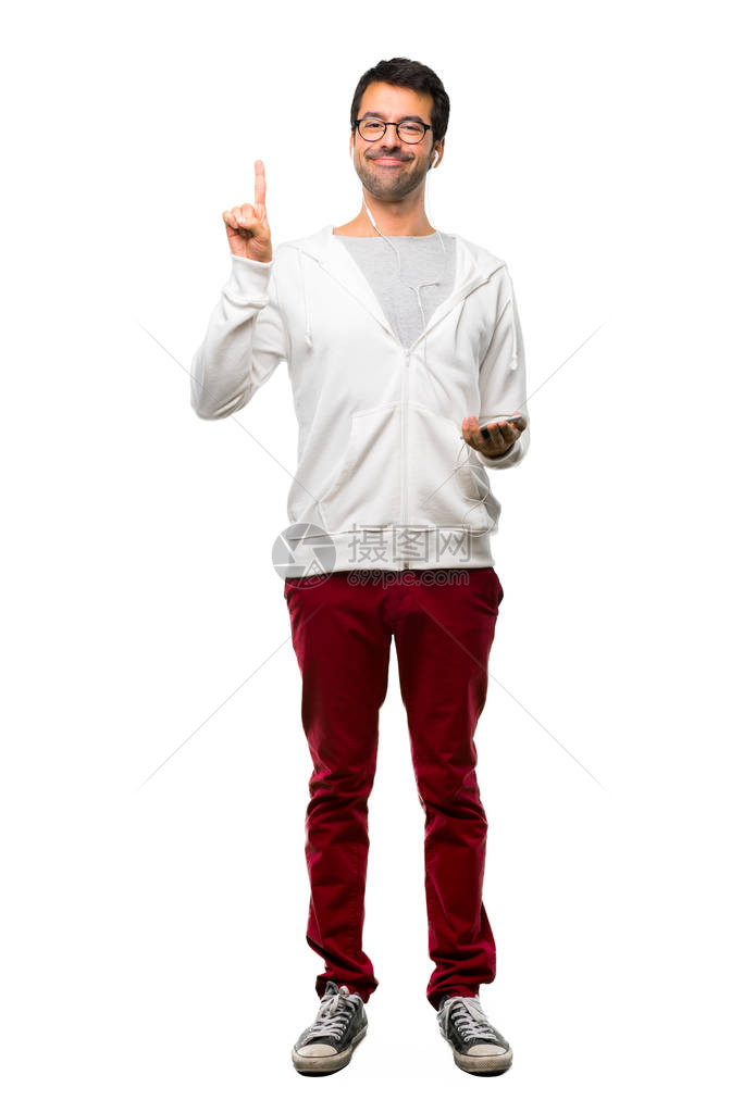 满身男人的全身带着眼镜和听音乐展出并举起一根手指在白色背景上图片