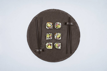 美食味的寿司和圆板上的筷子在图片