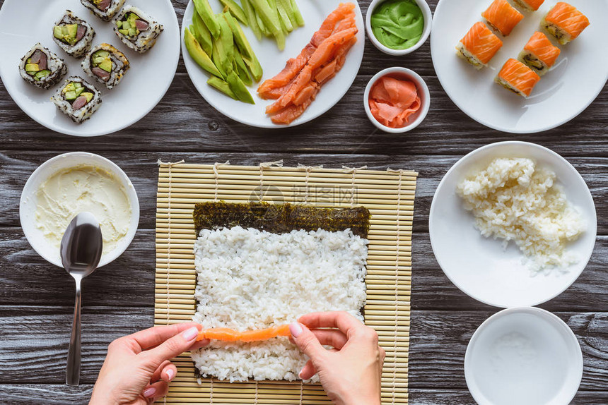 用三文鱼米饭和紫菜烹制美味寿司卷的人短片图片