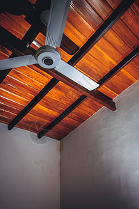 在一个棕色木天花板的背景的吊扇图片