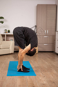 成年男子在锻炼时摆着大脚趾瑜伽的姿势图片
