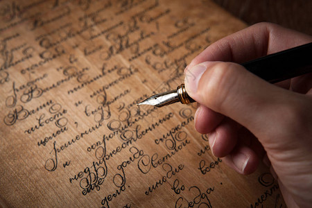 笔在手的钢笔上写着字背景图片
