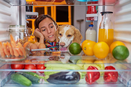 晚上深夜在冰箱前的女人和她的狗图片