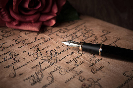 钢笔写在信上文字和红玫瑰特写背景图片